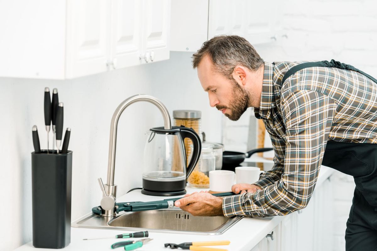 Plumber repairing a household faucet